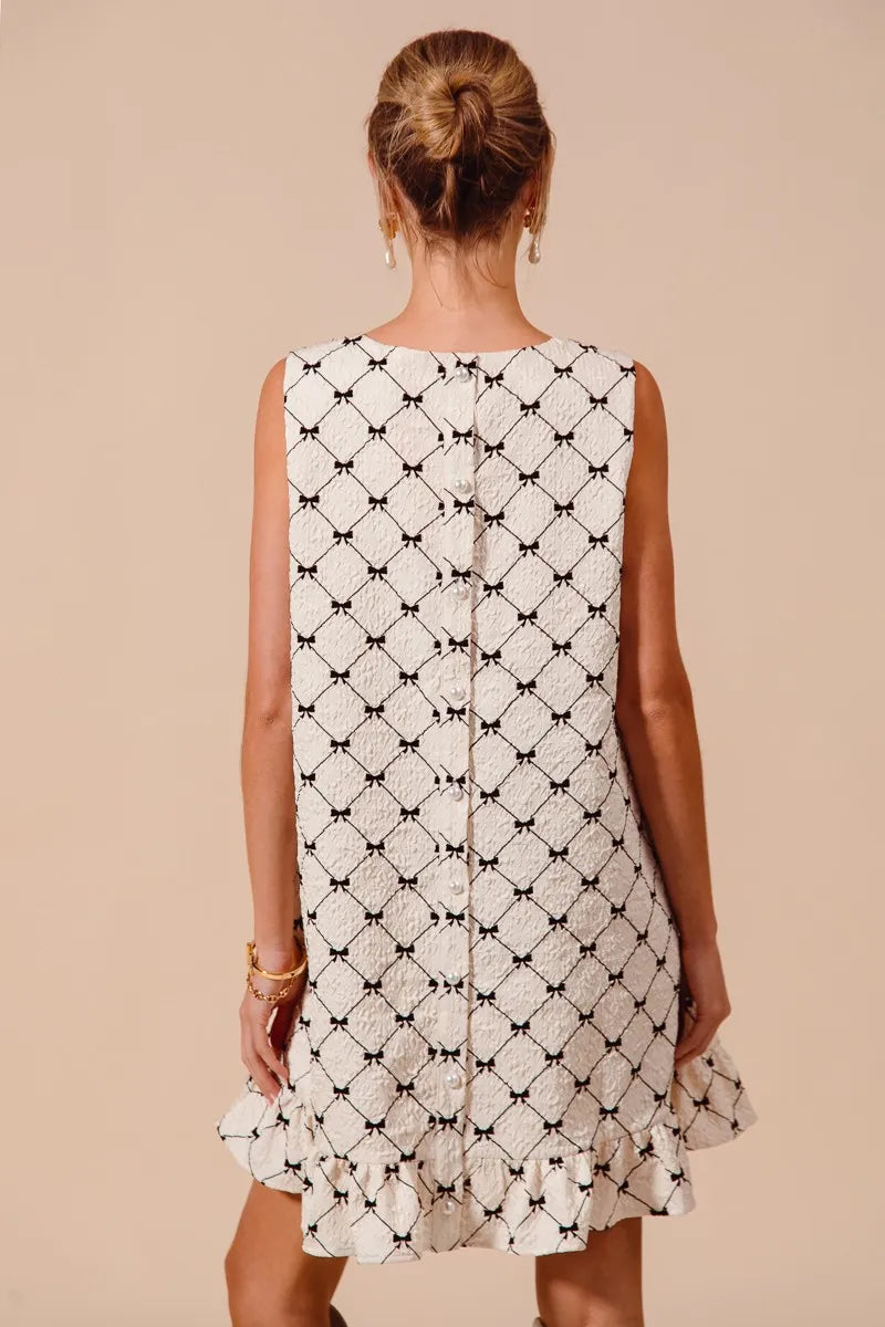 Back view of SO ME Texture Bow printed sleeveless mini dress with ruffle hem in black and white