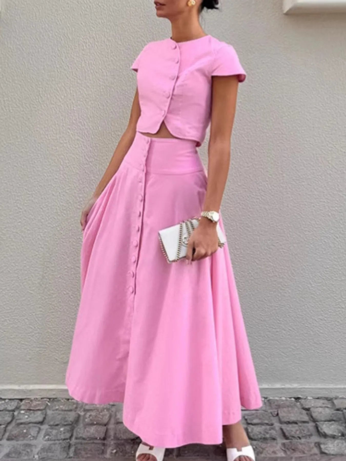 Woman wearing pink short sleeve top and skirt set with buttons, 100% cotton, stylish two-piece outfit