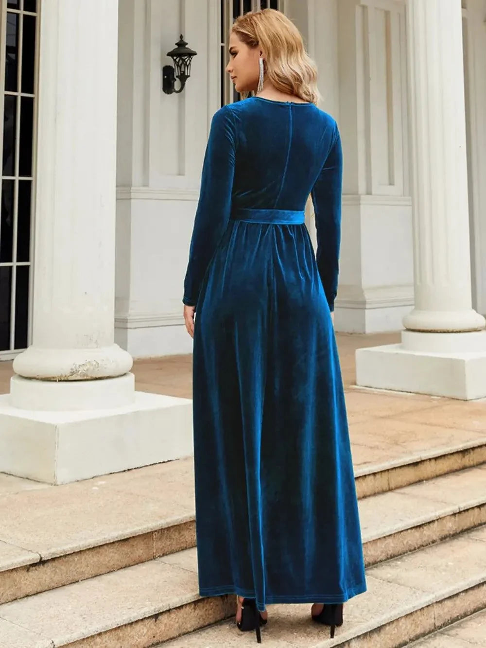 woman wearing blue tie front long sleeve maxi dress outdoors back view