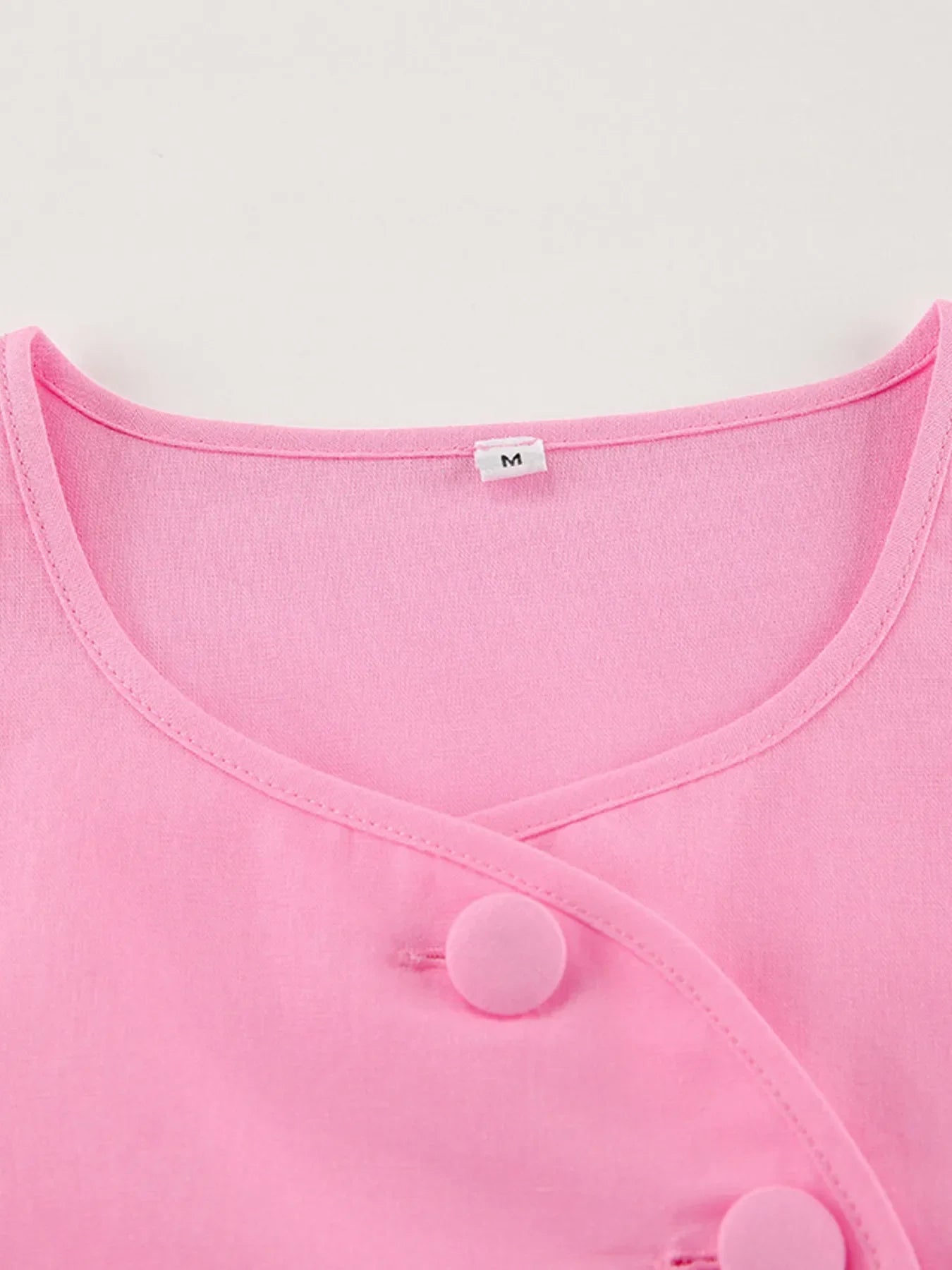 Pink short sleeve top with buttoned front and cotton fabric in medium size