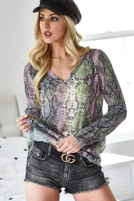 Woman wearing BiBi snakeskin print low gauge Hacci V-neck top with black shorts and a black hat