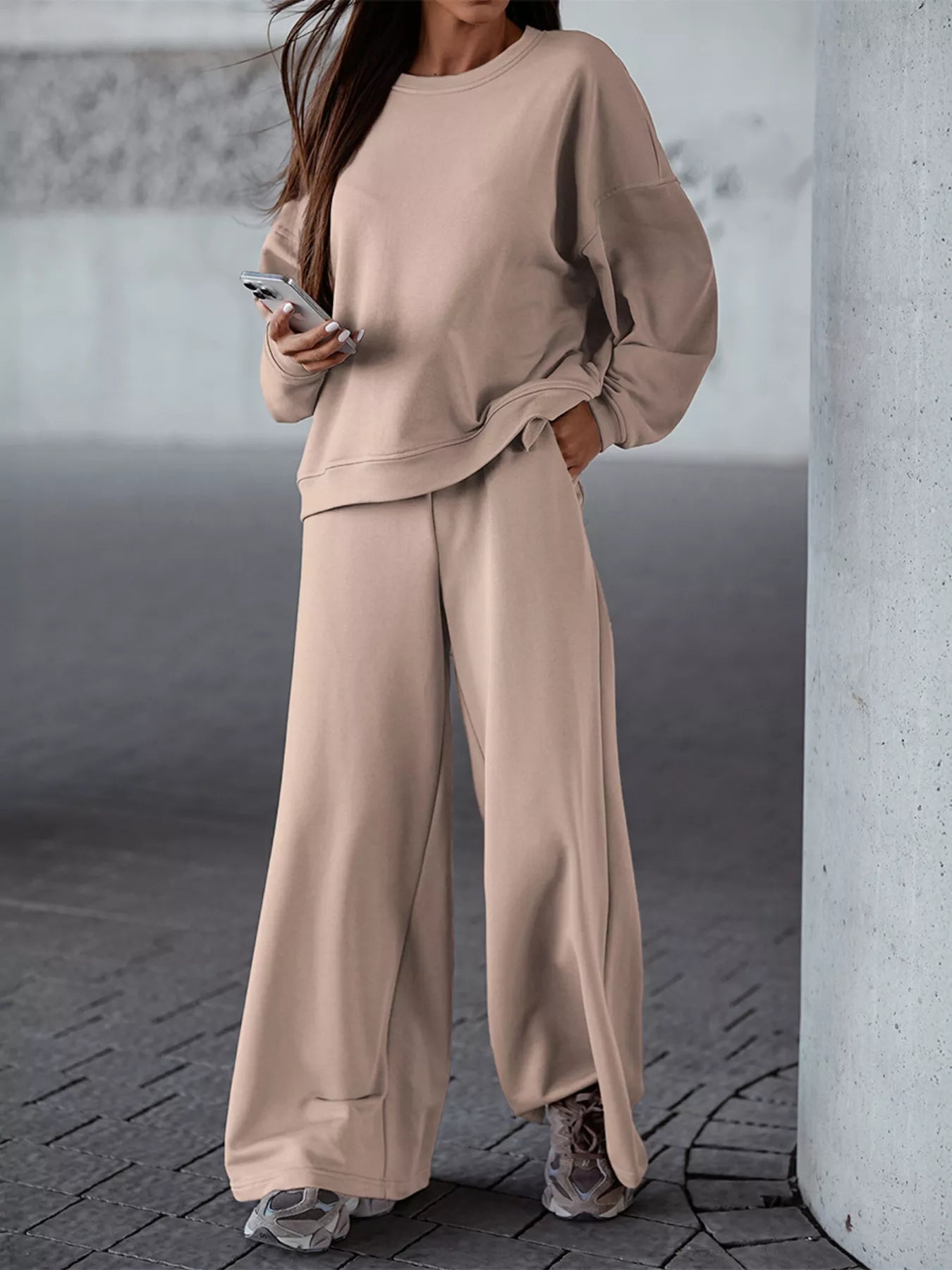 Woman wearing beige casual loose fit top and pants two-piece set with pockets and slightly stretchy fabric