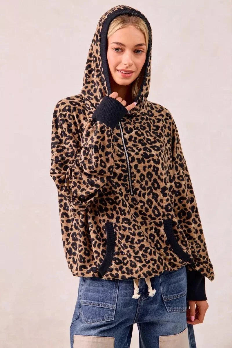 Leopard print waffle knit half zip hoodie with pockets and black cuffs worn by woman