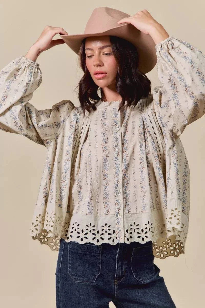 Woman wearing floral print lace button-down shirt with ruffled sleeves and eyelet hem