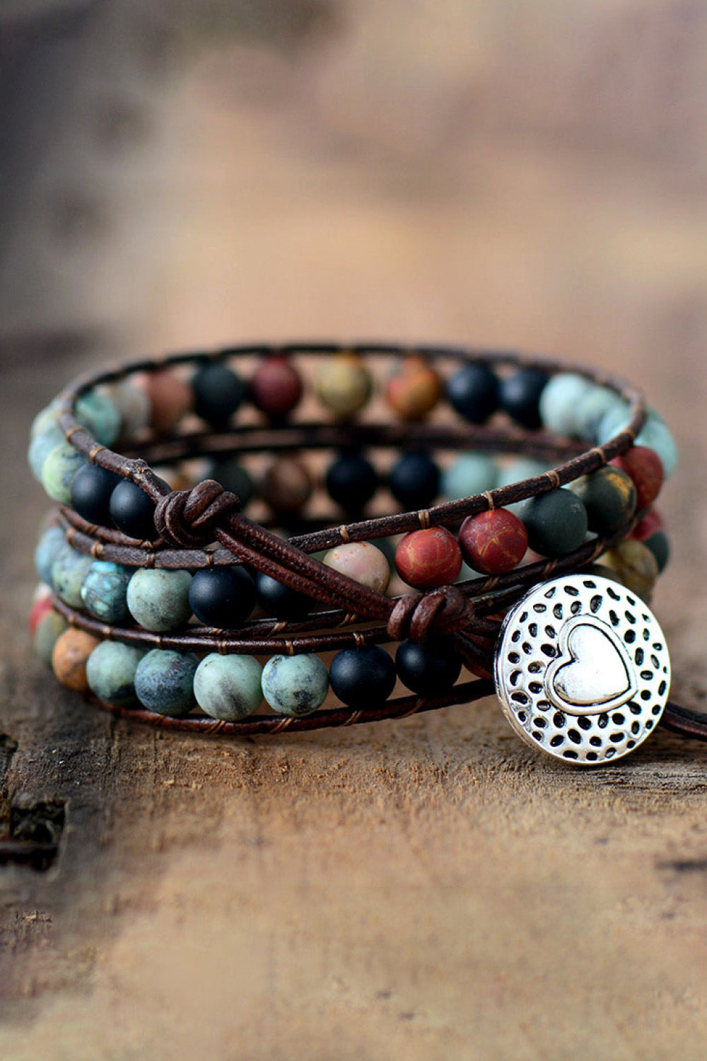 Handmade triple layer beaded agate bracelet with alloy heart charm on wooden background