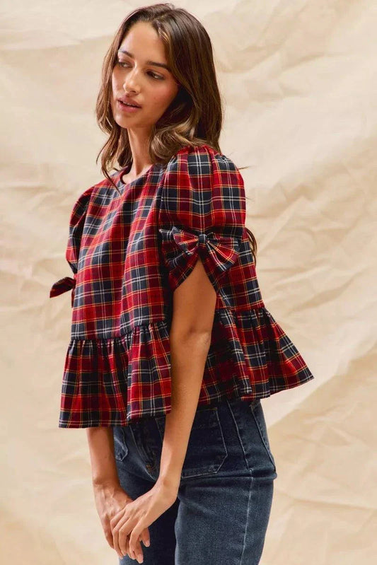 Woman wearing Christmas holiday plaid ribbon short sleeves top with ruffled hem and tied sleeves