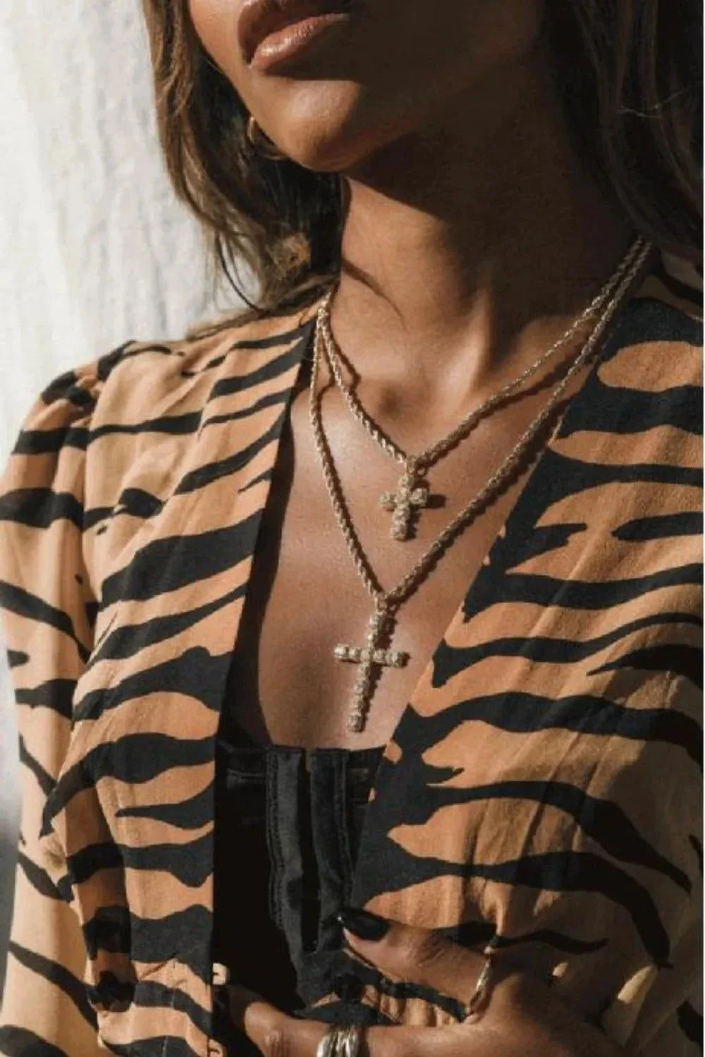 Woman wearing layered brass inlaid zircon cross pendant necklaces with gold-plated chains