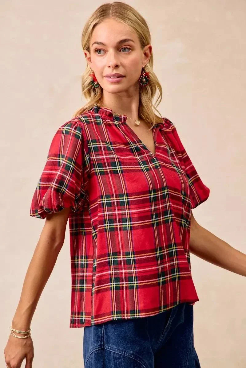 BiBi Christmas Plaid Short Sleeves Ruffled BlouseThis Christmas plaid short sleeves ruffled blouse is a festive and charming addition to your holiday wardrobe. The classic plaid pattern evokes a cheerful and cozy hChristmas plaid blouse