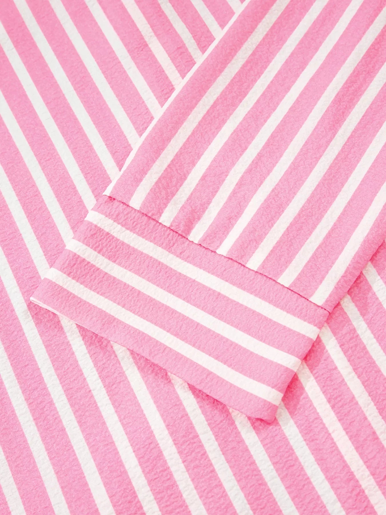 Close-up of pink and white stripe buttoned front long sleeve top fabric and cuff detail