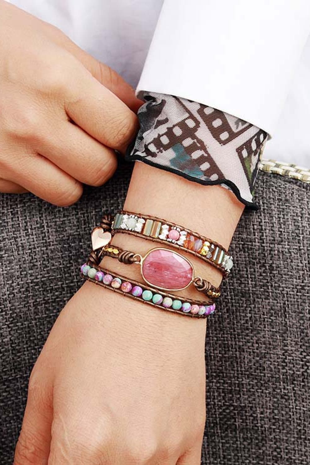 Hand wearing handmade crystal beaded natural stone bracelets with varied colors and designs