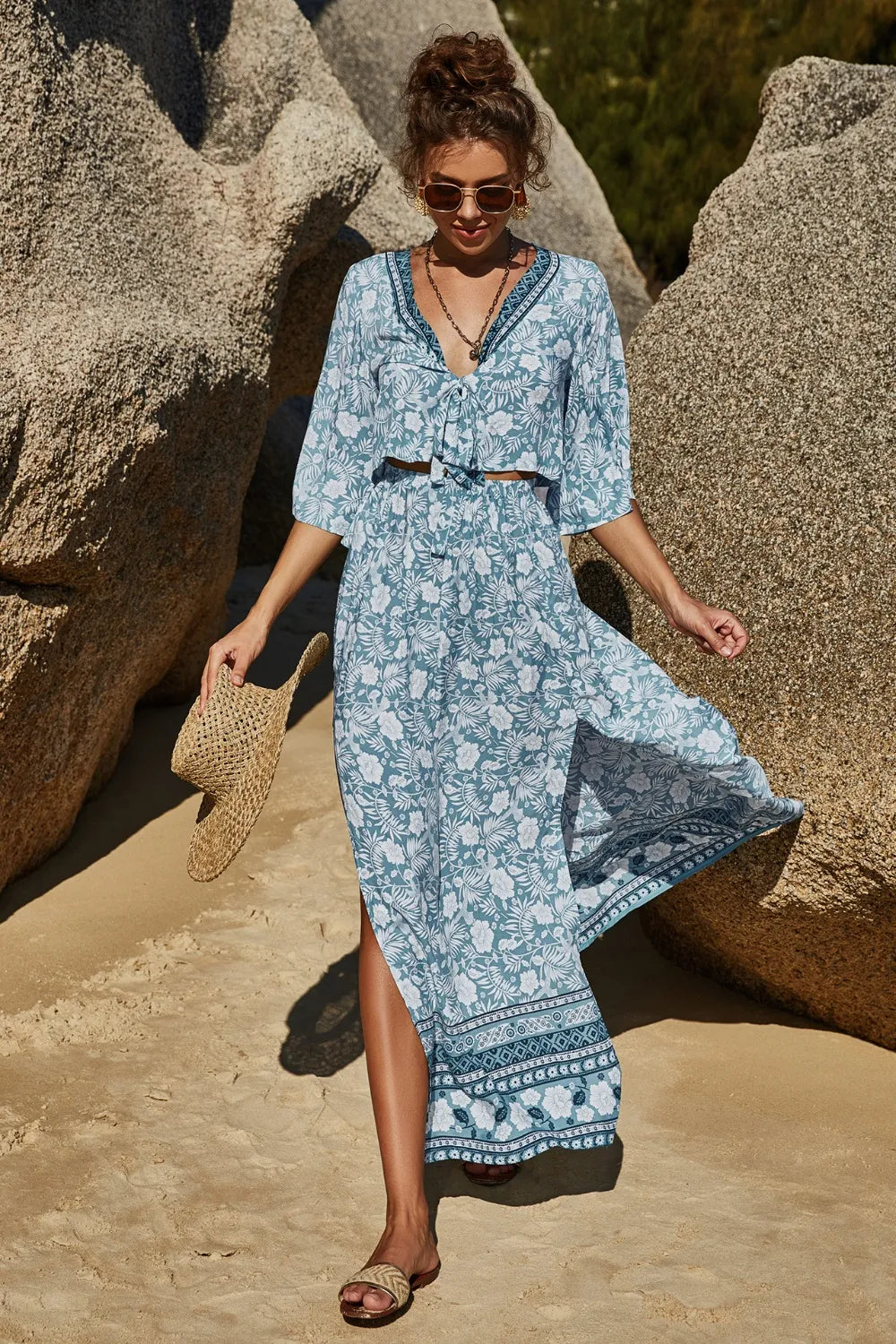 Woman wearing printed half sleeve top and slit skirt set in blue floral pattern on beach