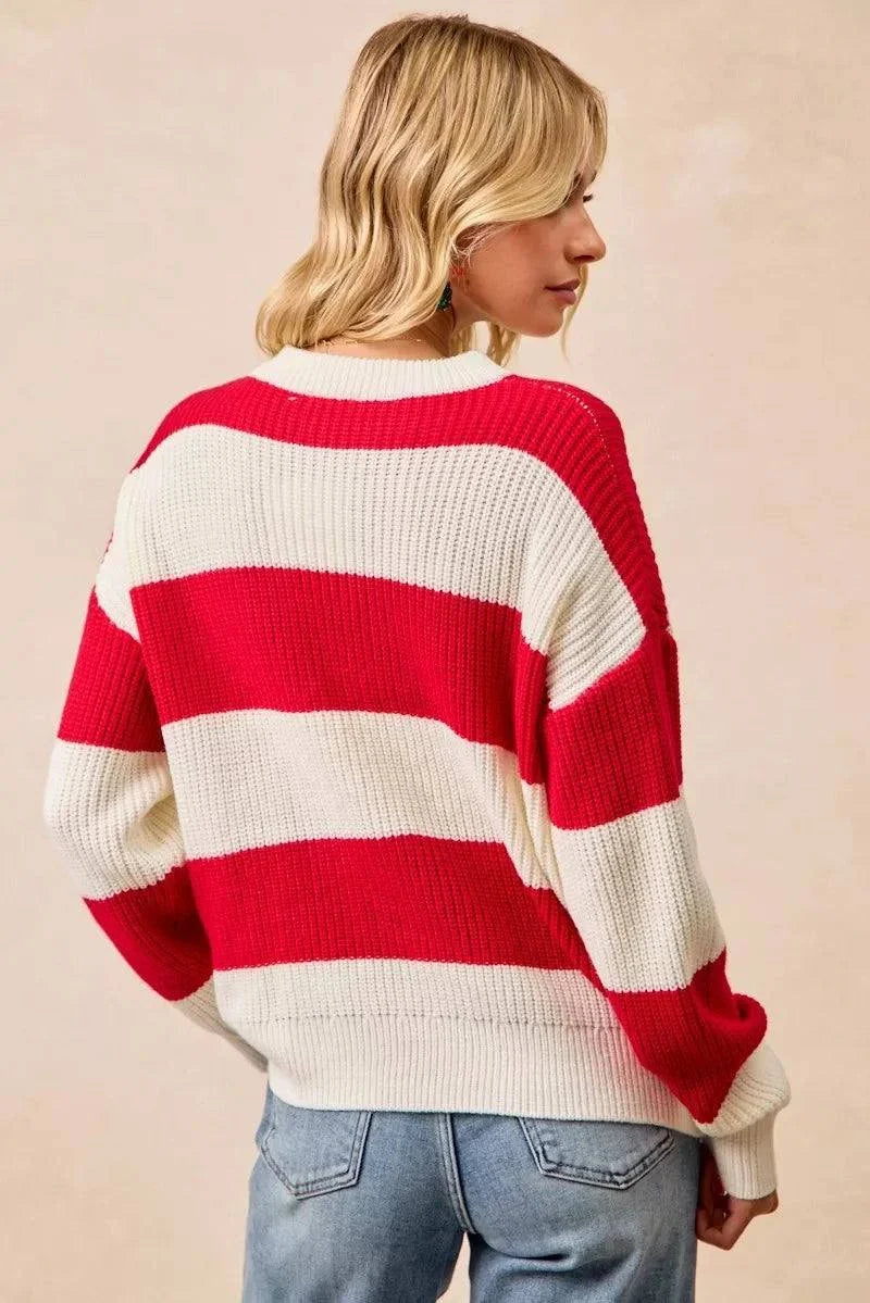 Woman wearing BiBi Christmas Merry Lettering Sweater with red and cream white stripes, oversized ribbed knit pullover.