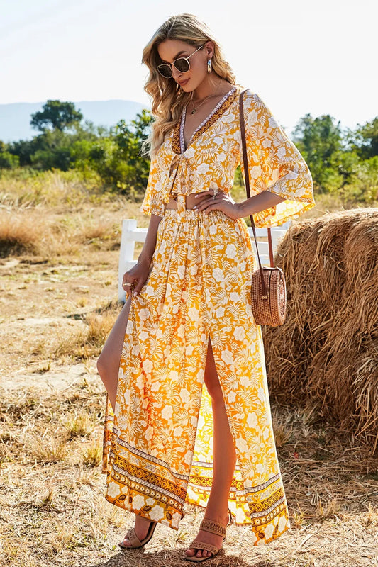 Woman wearing a yellow floral printed half sleeve top and slit skirt set outdoors