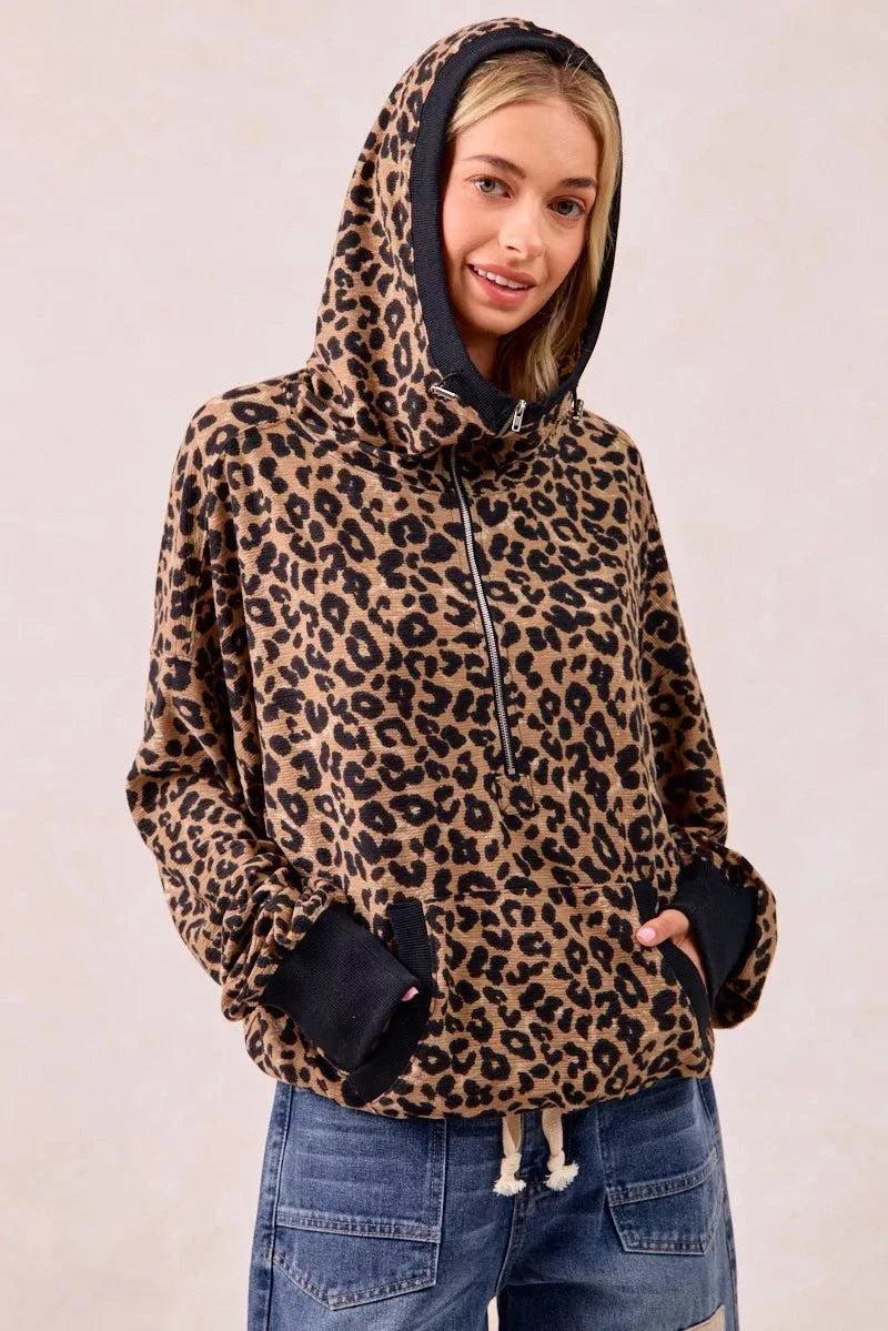 Woman wearing leopard print waffle knit half zip hoodie with pockets and black cuffs