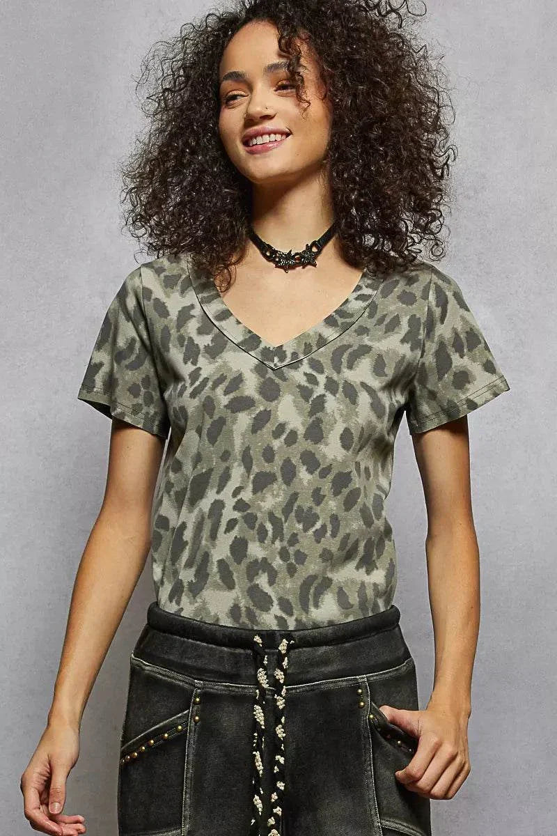 Woman wearing a POL Printed V-Neck T-Shirt with leopard print and black pants