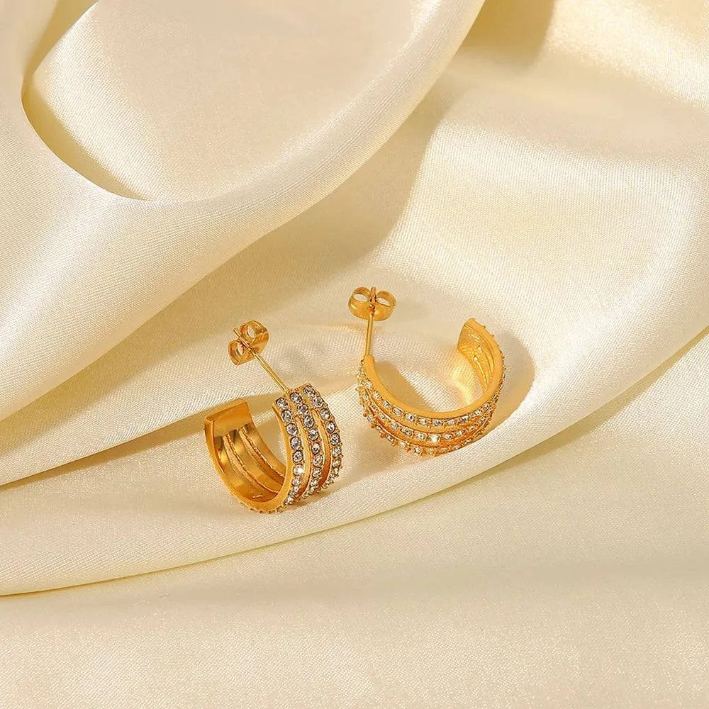 Gold-plated stainless steel C-hoop earrings with zircon inlay on satin background
