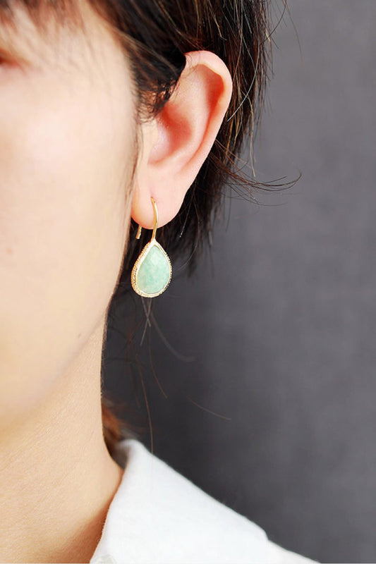 Handmade natural stone teardrop earrings with gold-plated copper setting worn on ear