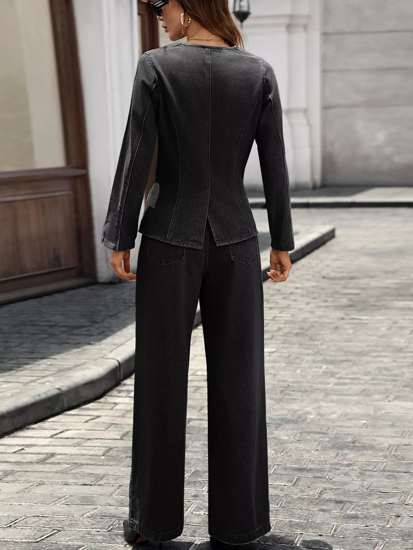 Back view of woman wearing black button up long sleeve top and jeans denim set with slightly stretchy fabric.