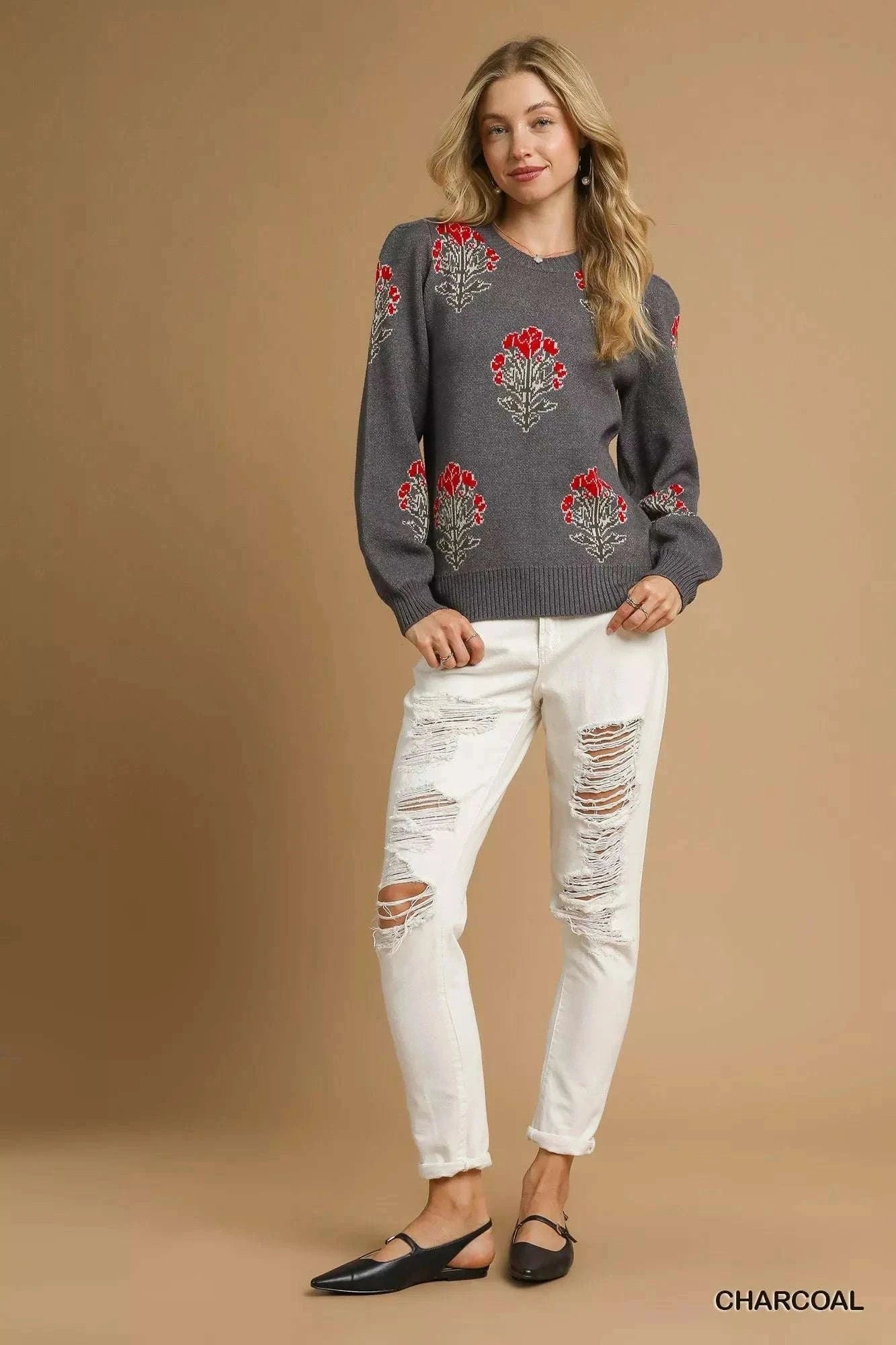 Woman wearing charcoal Umgee Single Flower Stem jacquard sweater with red floral design and white ripped jeans