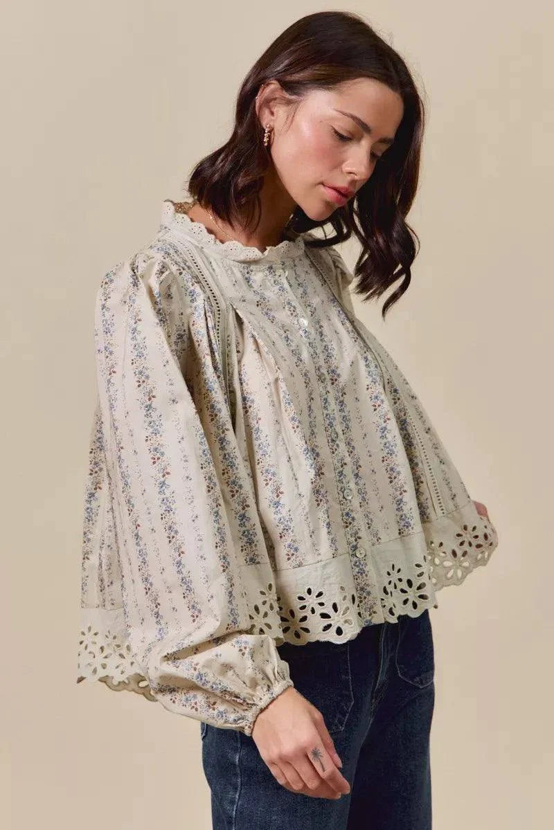 Woman wearing floral print lace button-down shirt with ruffled and eyelet lace details