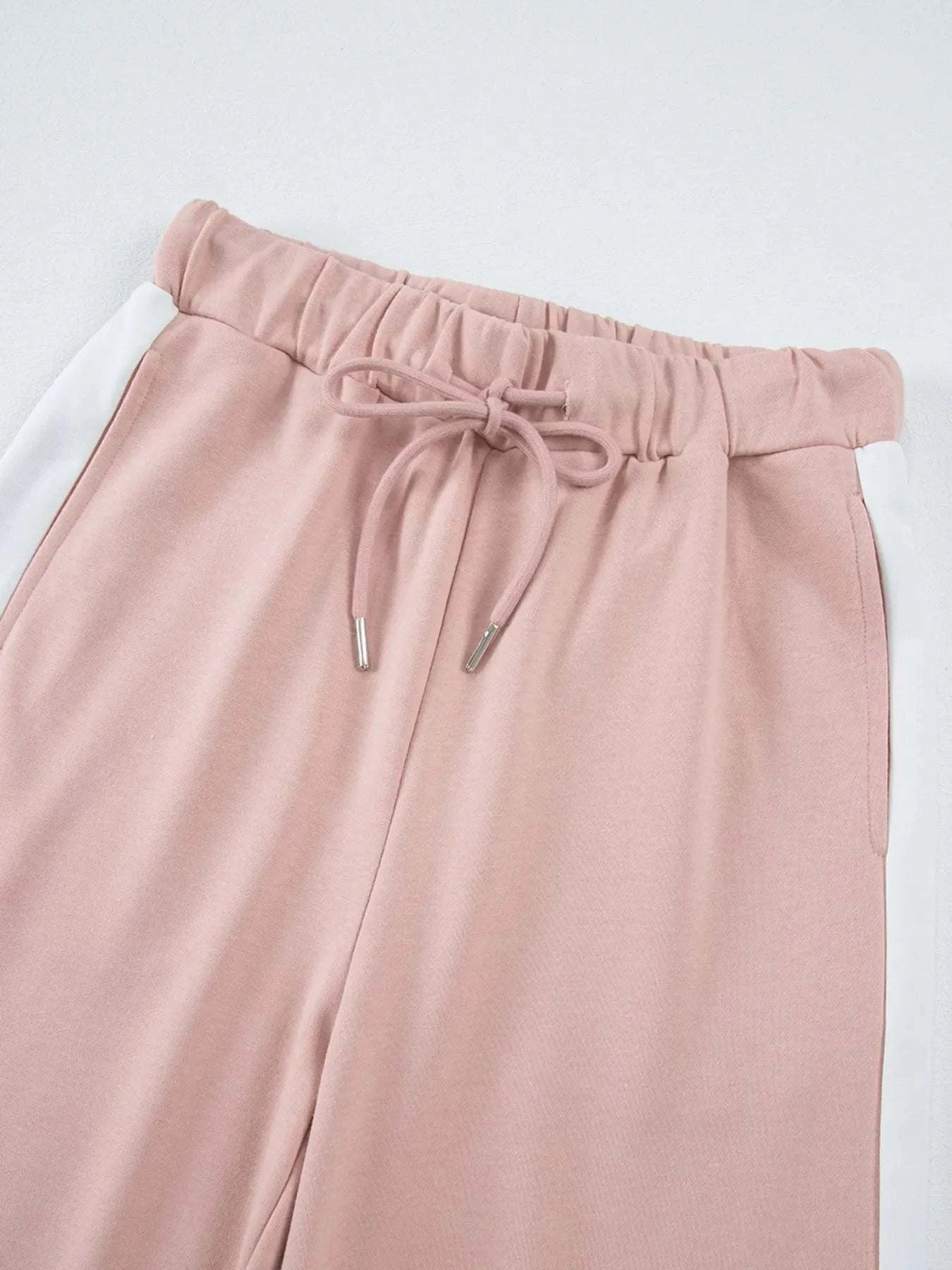 Close-up of blush pink pants with white contrast trim and drawstring waist, part of two-piece Contrast Trim Round Neck Top and Pants set.