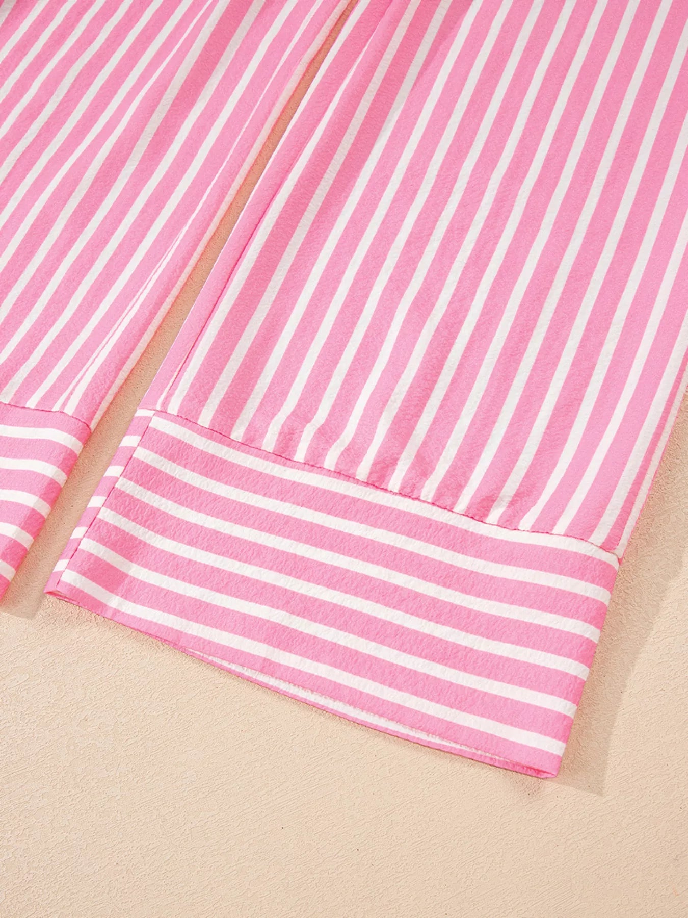 Close-up of pink and white stripe buttoned front long sleeve top and pants sleepwear set cuffs
