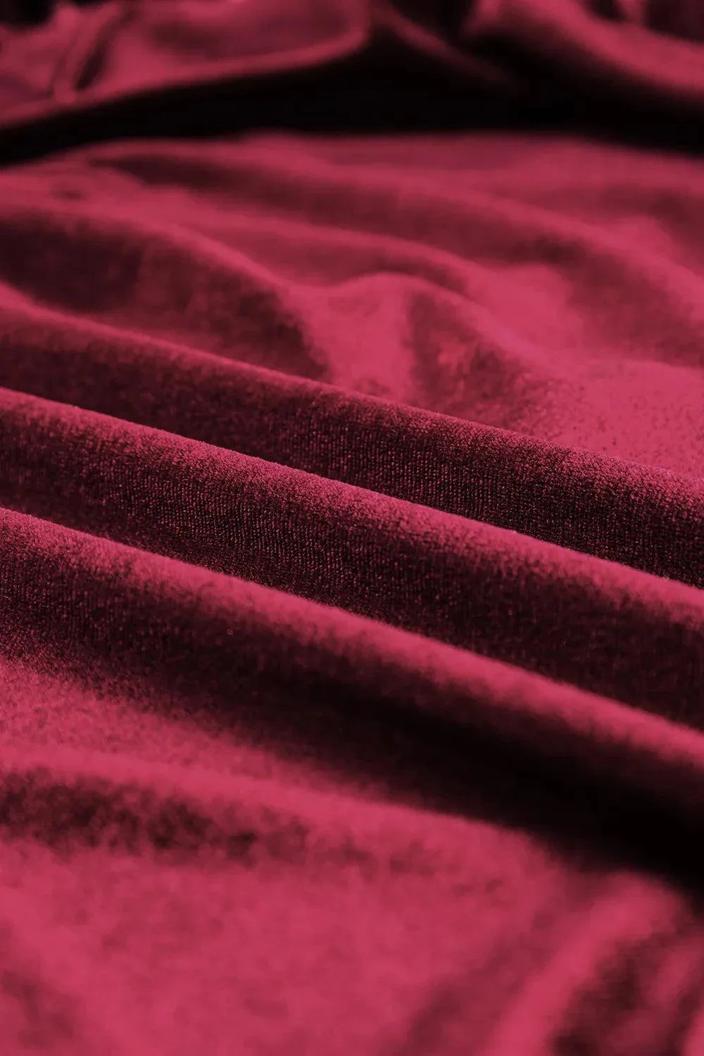 close-up of deep red fabric for Sequin Notched Long Sleeve Blouse with slight stretch and opaque texture