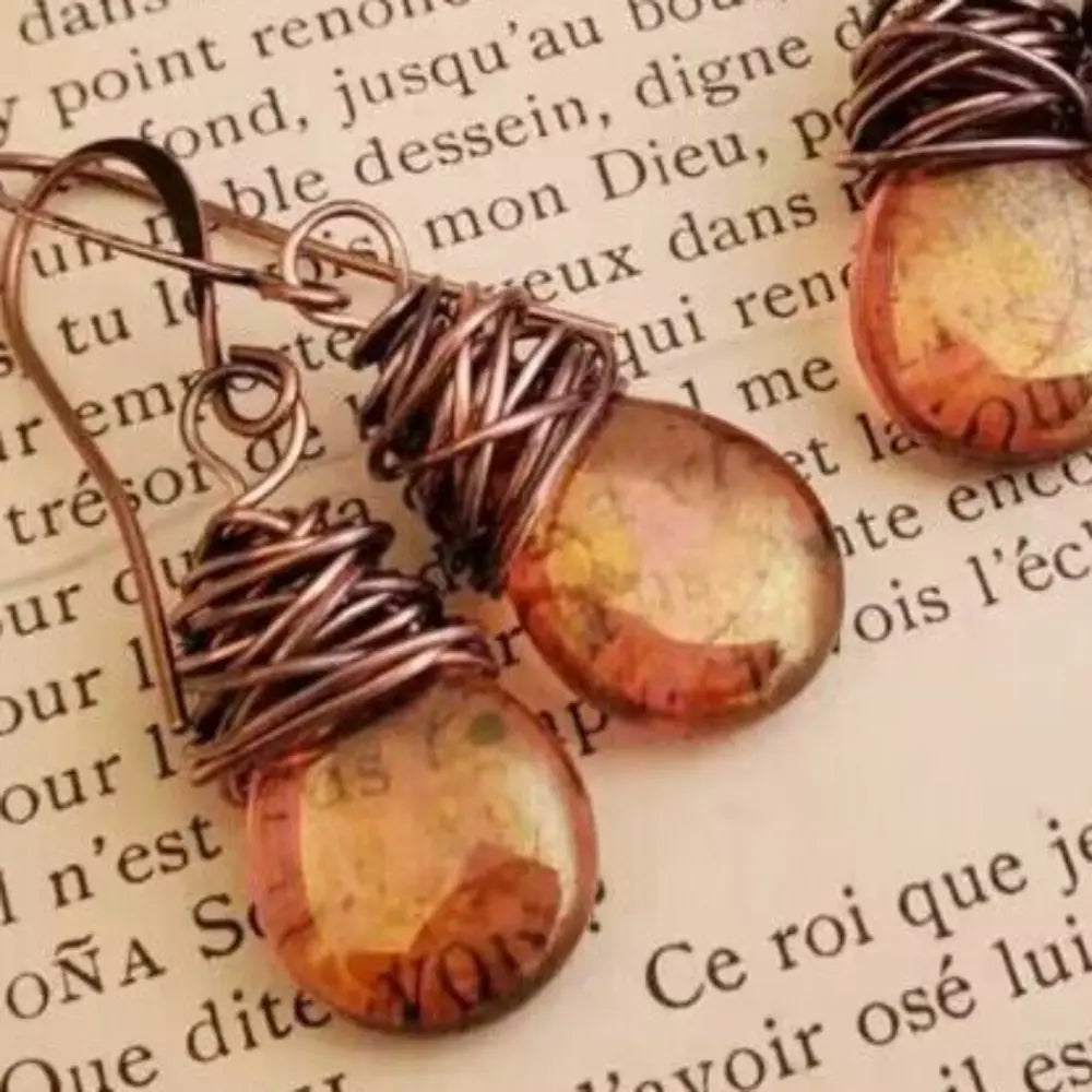 Alloy gemstone drop earrings with amber-colored stones and wire wrap design on text background