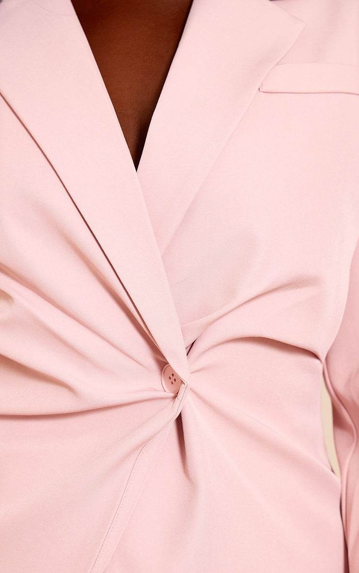 Close-up of plus size pale pink tailored cinched waist blazer with button detail