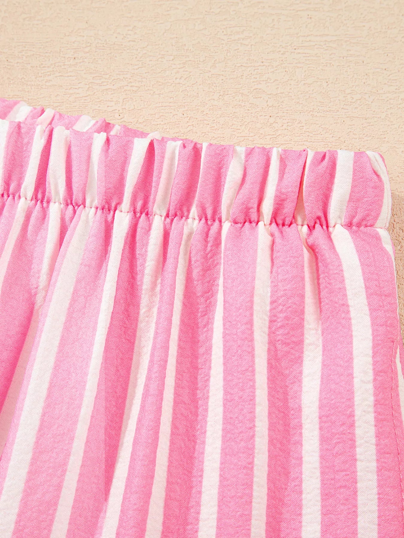 Close-up of pink and white striped buttoned front long sleeve top and pants two-piece sleepwear set