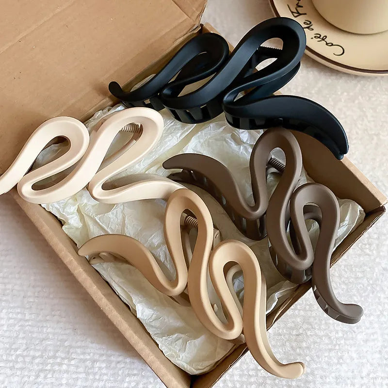 Set of alloy acrylic hair claw clips in various colors displayed in an open box