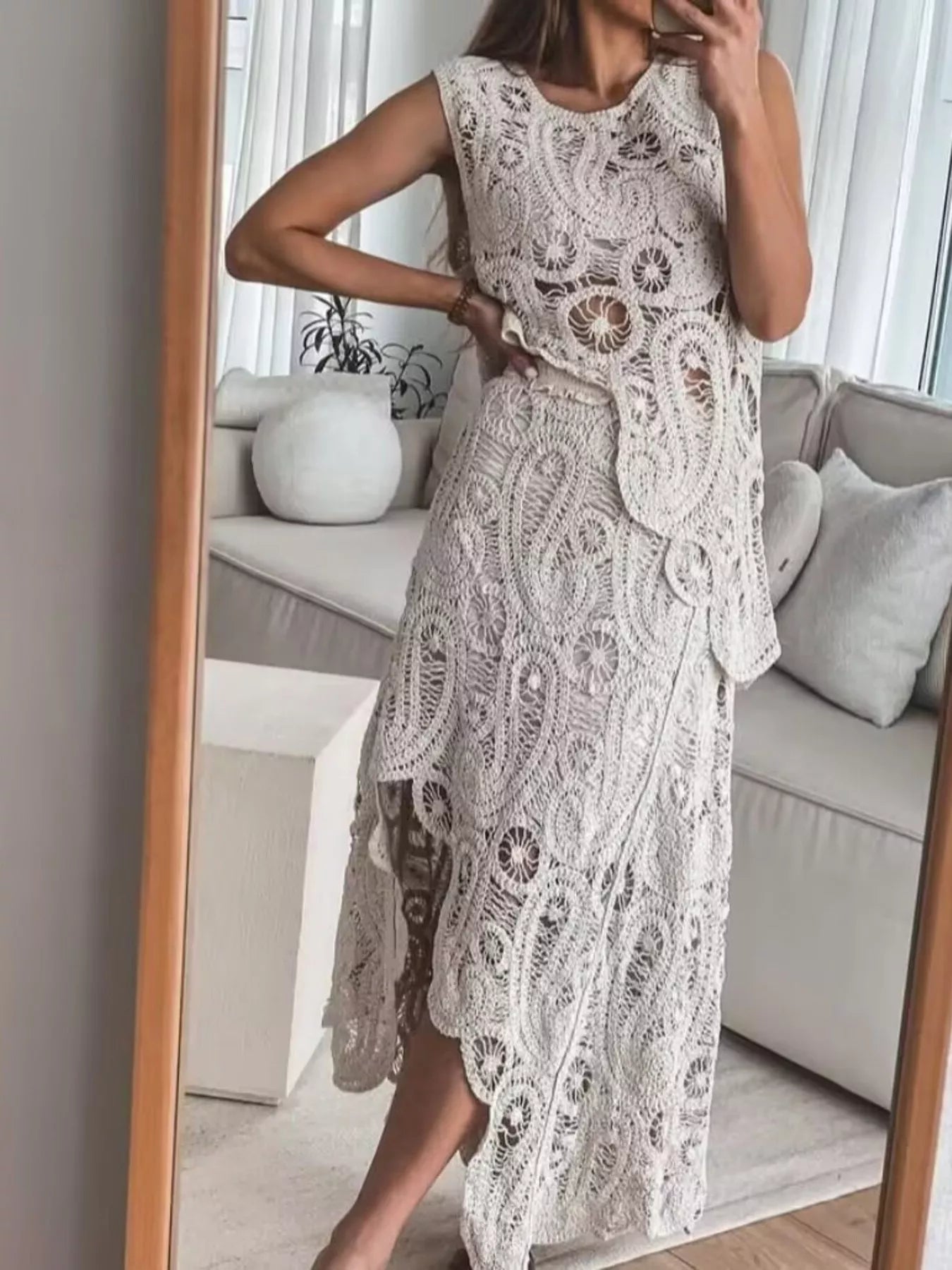 Woman wearing crochet sleeveless tank and asymmetrical skirt set in white openwork polyester fabric