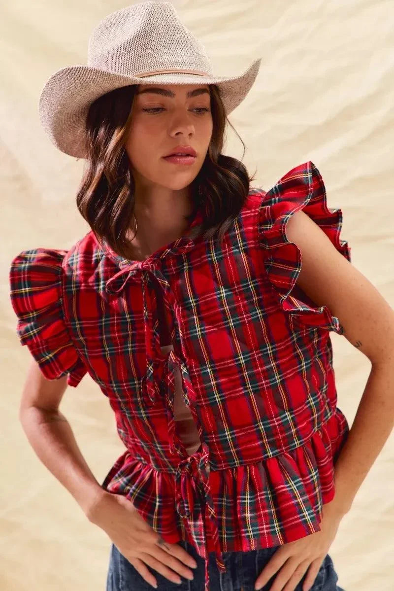 Woman wearing a Christmas holiday plaid red ruffled quilt vest top with tied front and layered design