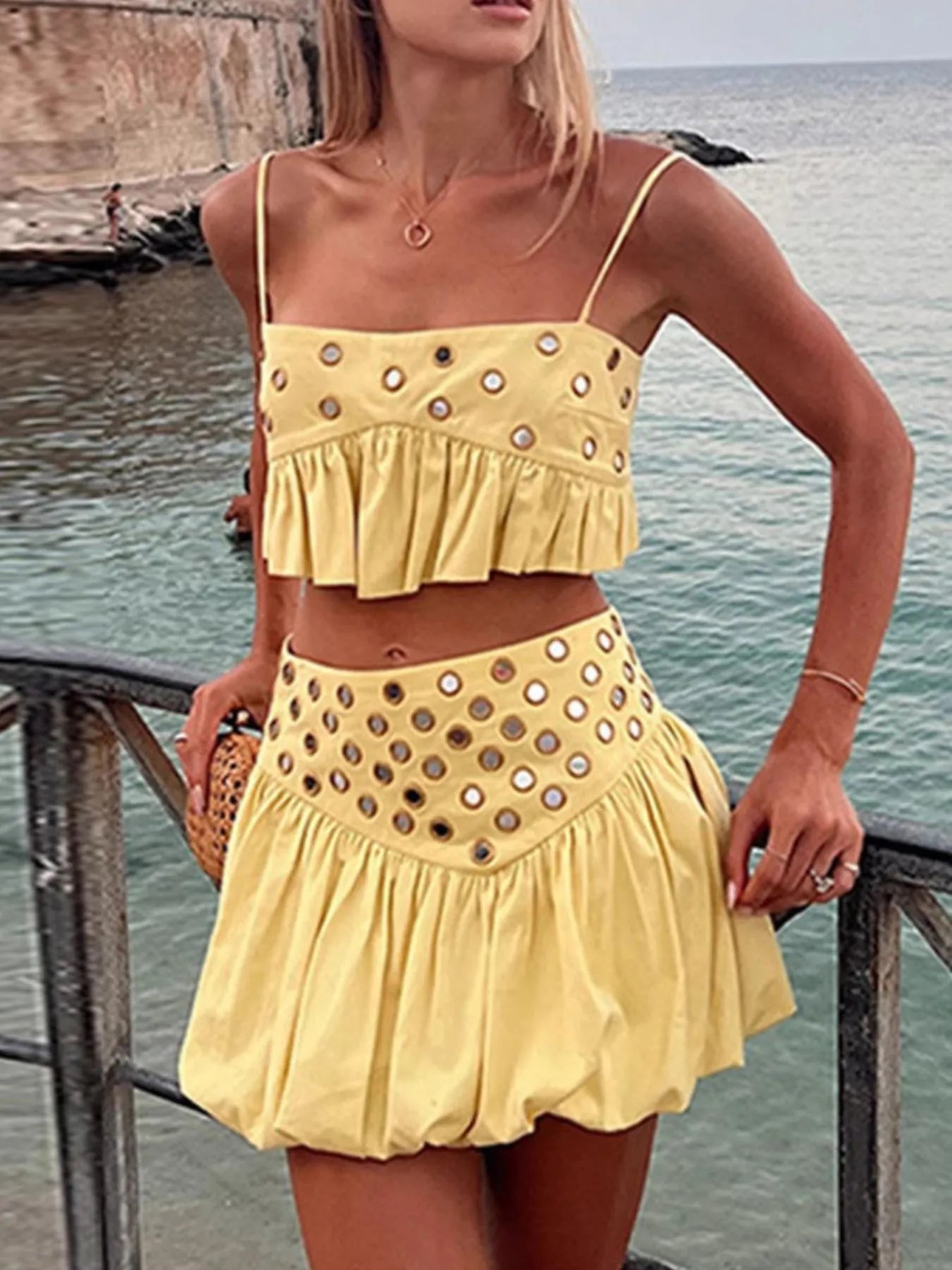 Yellow eyelet cami and bubble skirt set with cutout and ruffled details by water
