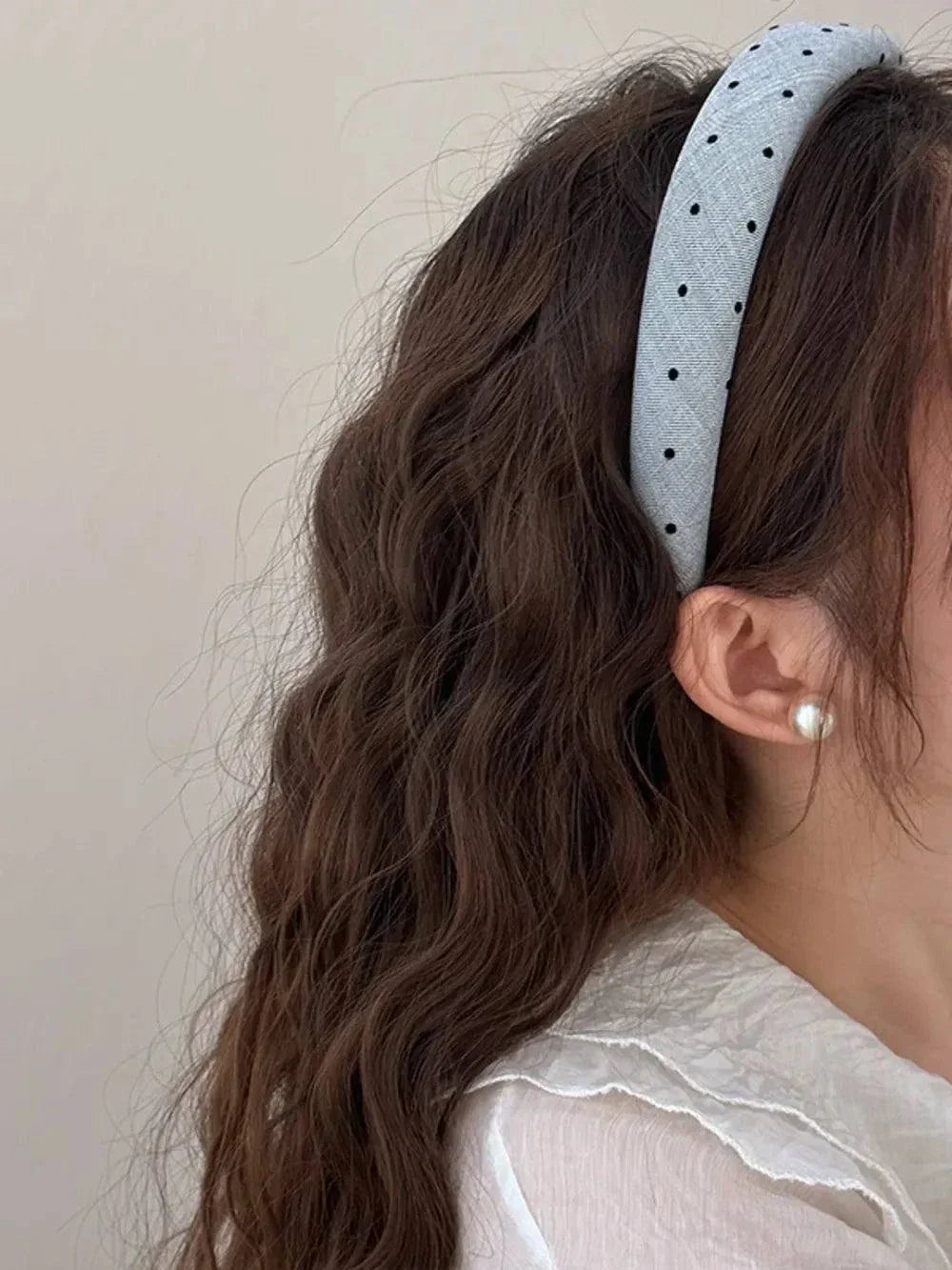 Polka dot polyester wide headband on woman with wavy brown hair and pearl earring