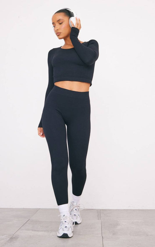 black structured contour ribbed leggings worn with black long sleeve crop top and white sneakers on model