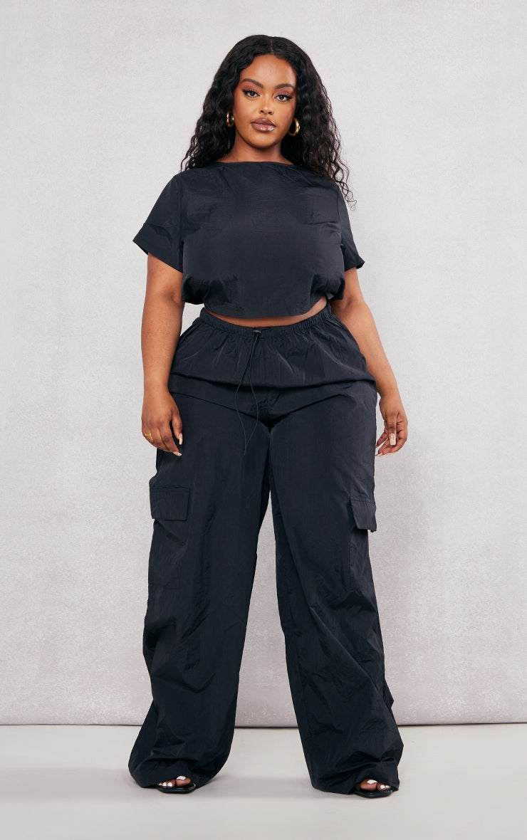 Plus Black Nylon Wide Leg Cargo TrousersReimagine your everyday uniform with these black nylon wide-leg cargo trousers. Cut from a durable, subtly textured nylon, they offer both structure and a relaxed siRedemption By Ashley NorthPlus Black Nylon