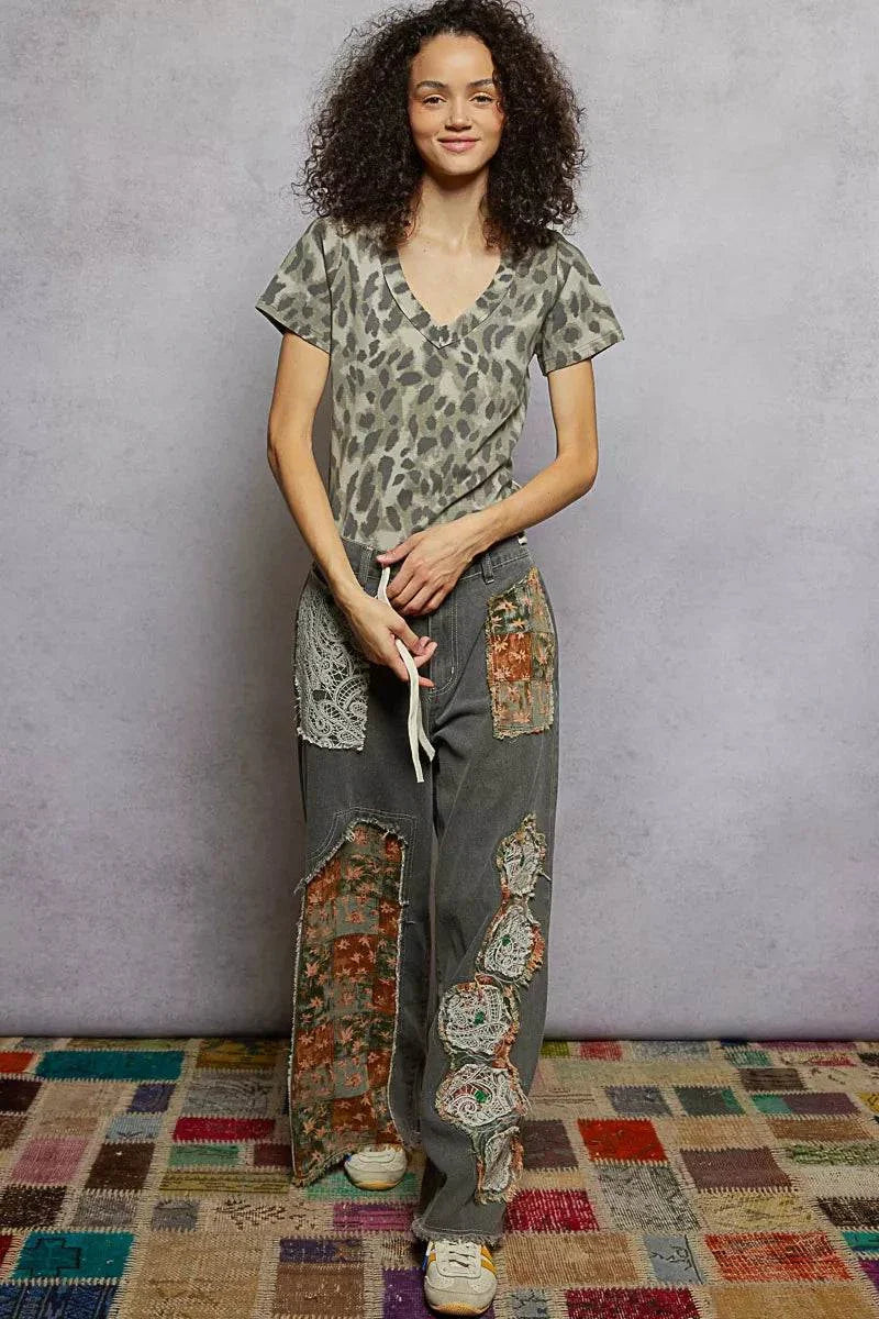 Woman wearing POL printed V-neck short sleeve t-shirt with animal print design and casual pants.