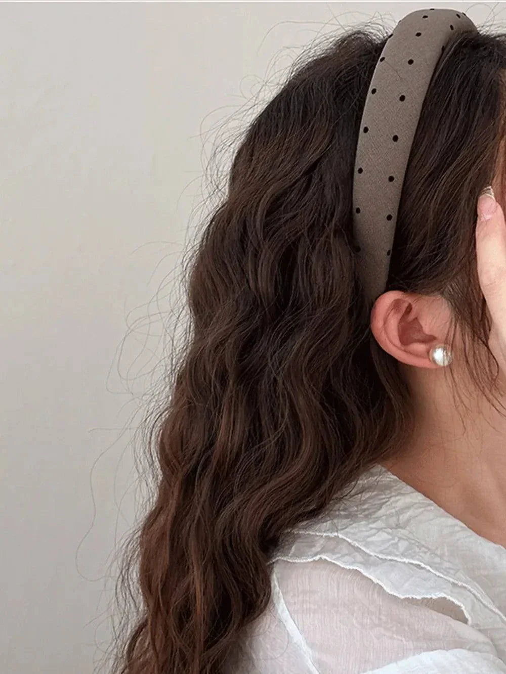 Polka dot polyester wide headband on woman with wavy hair and pearl earring