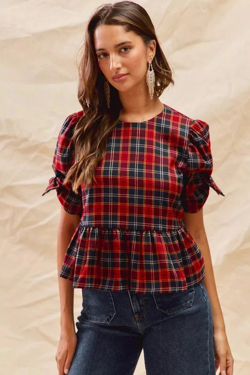 Woman wearing Christmas holiday plaid ribbon short sleeve top with ruffle and tie details