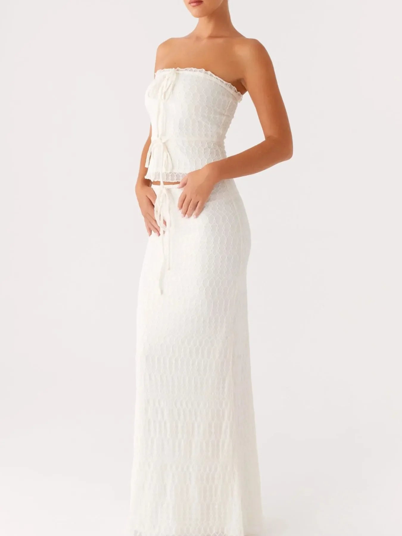 White two-piece tie front tube top and maxi skirt set with lace detail, slightly stretchy polyester fabric.